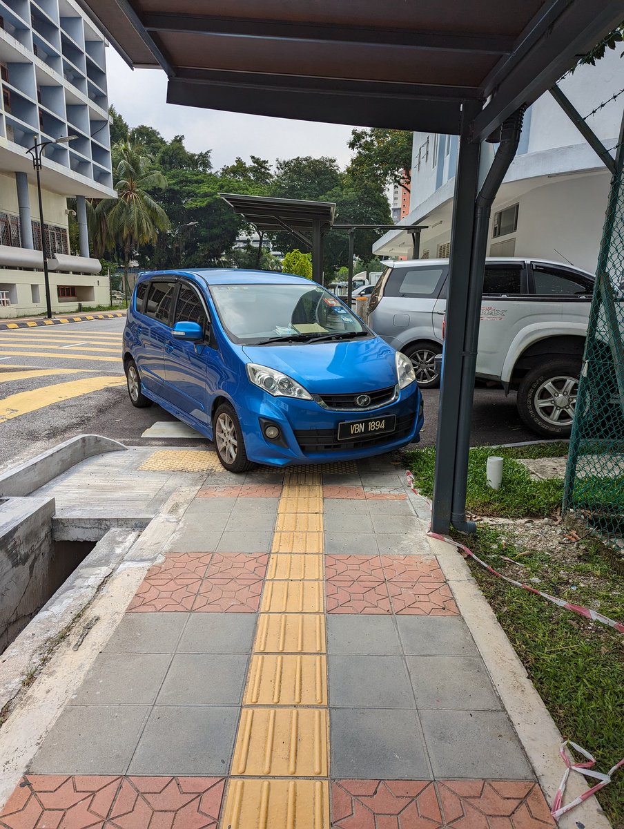 Dafrosty's tweet photo. Accessibility in Malaysia in a picture:

Newly renovated section of the sidewalk in HKL, that took years to complete without safer pedestrian alternatives, ends up as an entitled parking spot for a low cost car, built by a local industry shielded from competition https://t.co/WJ1hrCBtBD