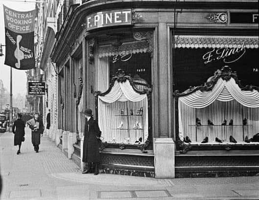 A photograph of a policewoman peeping  round the corner into New Bond Street from outside the luxury shoe and bootmaker F. Pinet on the corner with Maddox Street, in May of 1939. 
The premises are still there and are now occupied by the fashion accessory and leather goods shop…