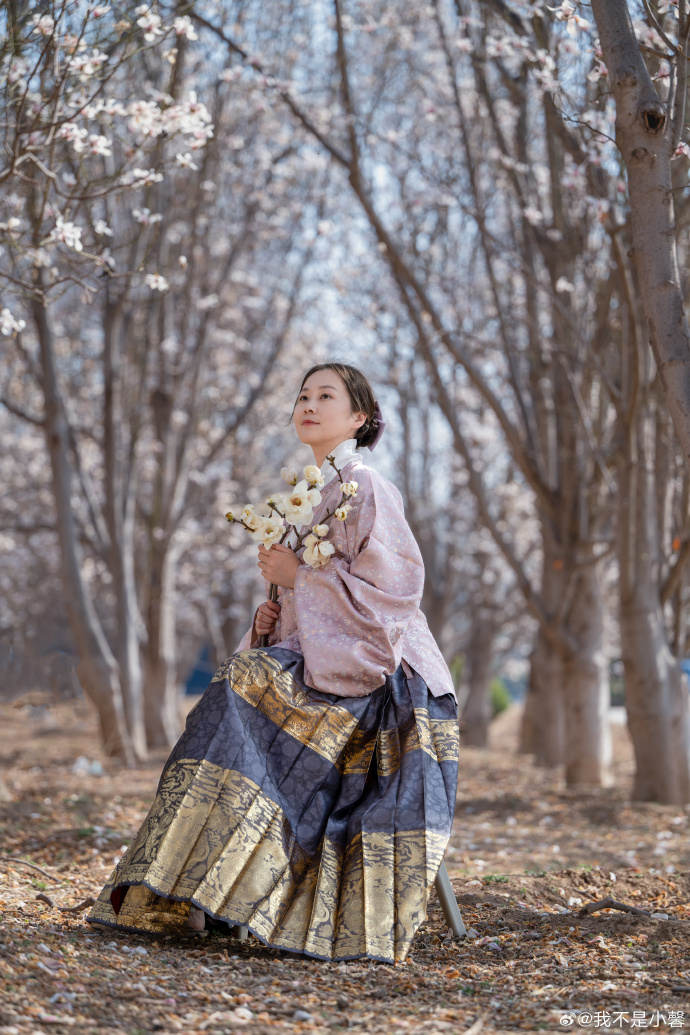 Magnolias are blooming with full vitality while a blogger shows off a new outfit of the day (#OOTD): a cross-collared Hanfu short robe and Mamianqun.（via: Wobushixiaoxin）