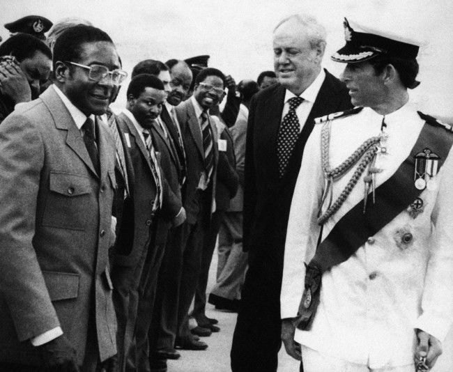 Britain’s Prince Charles shares a word with Prime Minister Robert Mugabe for a few moments after his arrival to hand over power to a new independent Zimbabwe at the stroke of midnight on April 17 1980.