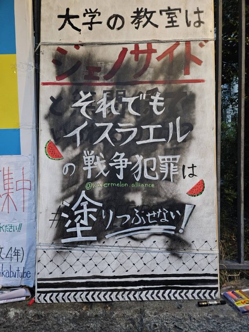 塗りつぶされた立て看板の上に「それでもイスラエルの戦争犯罪は塗りつぶせない」とかかれている。