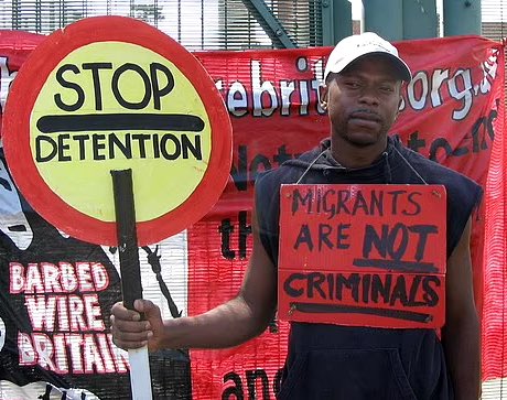 Asylum Seeker who held sign reading ‘Migrants are NOT Criminals’ had pled guilty to r*ping a 15 year old girl. 

The Congolese migrant, who claimed his life was at risk when he arrived in the UK, has been a vocal migrant rights activist demanding migrants be given rights and…