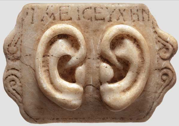 Roman Votive Ear Panel, 1st-3rd century AD Made from marble with a Greek inscription “'IAEICEYXHN”“(?). Votive offerings were presented to a god, sometimes either in the hope of a cure or as thanks for one. They were made in the shape of the afflicted body part – in this case a