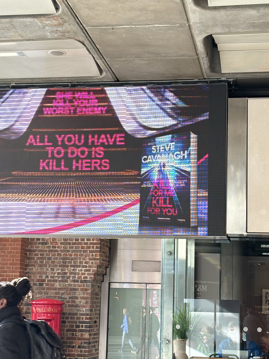 ⁦@SteveCavanagh_⁩ on the huge screens at St Pancras taking over the world. Looking good! (One day I too will have a giant screen of my book. Or a giant billboard. Or a small Tube poster is fine. Or at this point I’d take a Polaroid stuck to a bus with masking tape 😂)