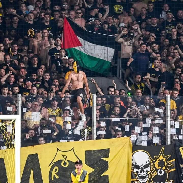 The flag of Palestine is presented during a match between AEK Athens  and Ajax, Amsterdam.