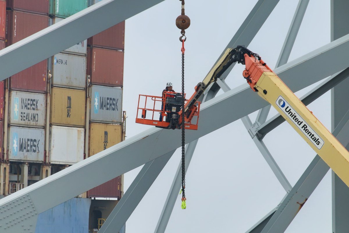 A worker in a crane basket inspects a portion of the collapsed bridge to determine where it will be cut before being removed from the #PatapscoRiver. @wbalradio @USACEBaltimore #Baltimore #KeyBridgecollapse #keybridgenews