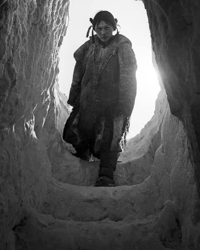 An Inuit girl, Helen Konek, walks into a massive igloo constructed by her father Pipqanaaq, near Arviat, Nunavut, on the shores of Hudson Bay, in the 1950s.