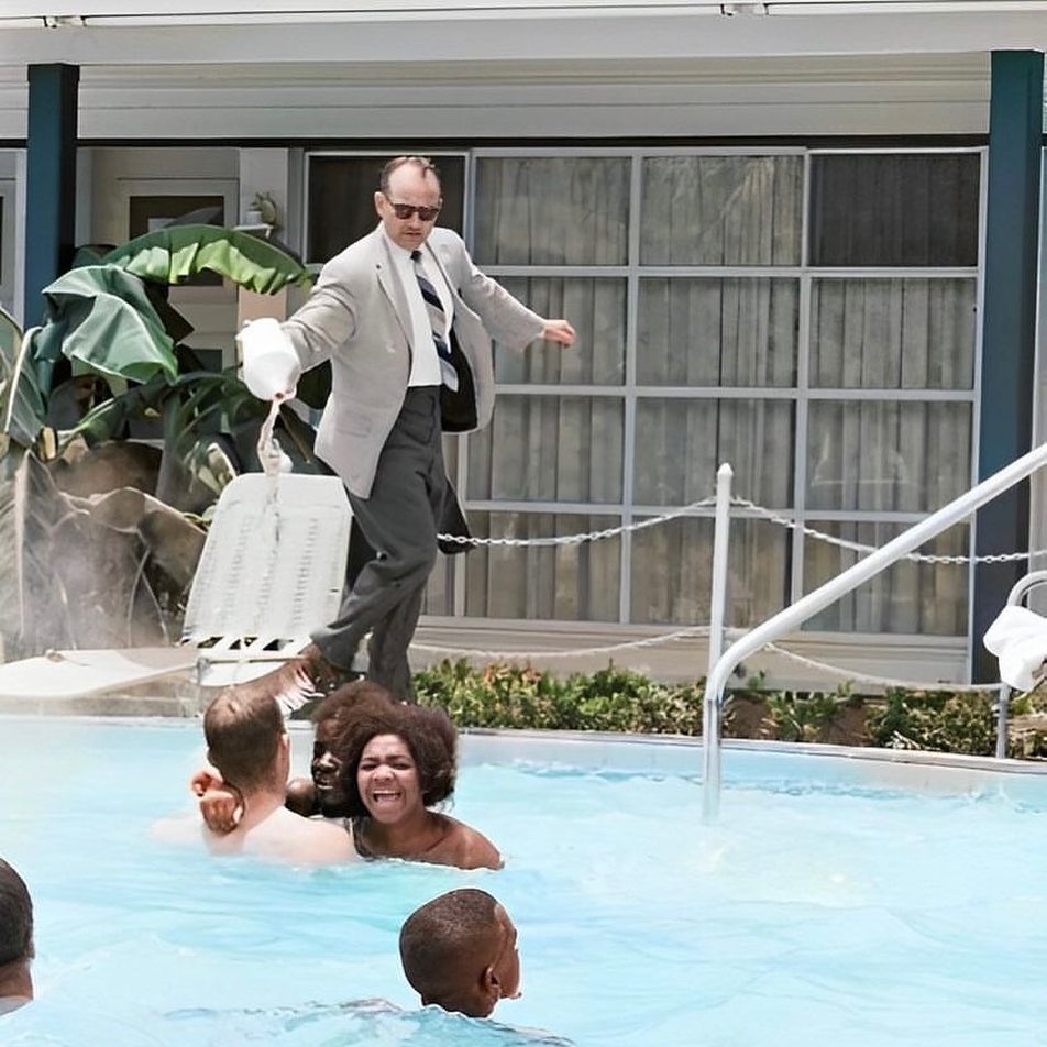 Motel manager James Brock pours muriatic acid In the Monson Motor Lodge swimming pool, to get black swimmers out of the pool. (June 18, 1964)