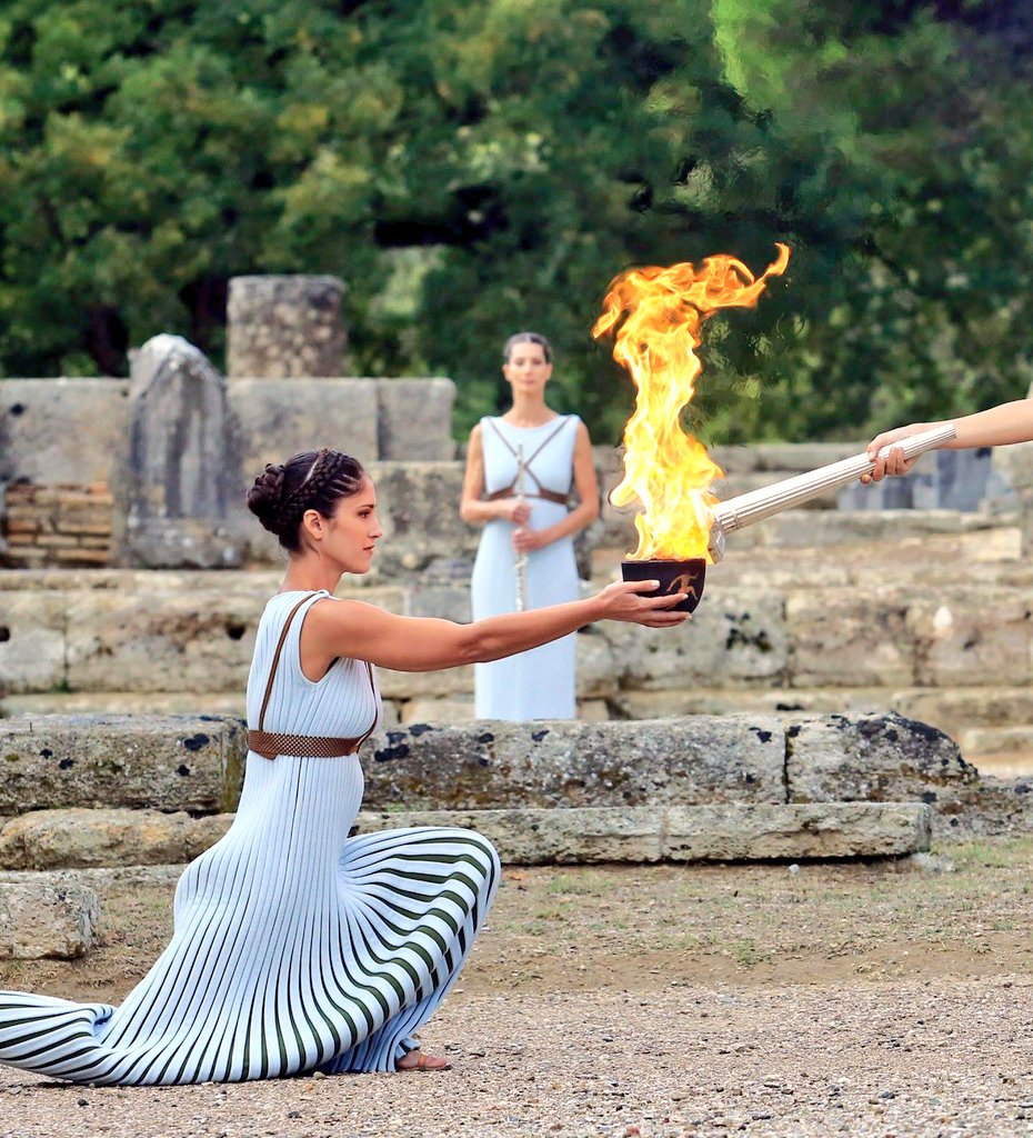 KirenRijiju's tweet photo. The Olympic flame is a symbol used in the Olympic movement. It is also great symbol of continuity between ancient & modern games. Olympic flame is ignited in a spellbinding ceremony some months before the opening ceremony of the Olympic Games at the main site of ancient Olympics in Olympia, Greece.
11 women, representing the Vestal Virgins perform a celebration at the Temple of Hera at Olympia in Greece in which the first torch of the Olympic Torch Relay is kindled by the light of the Sun and carried around the world, finally to the current host city.