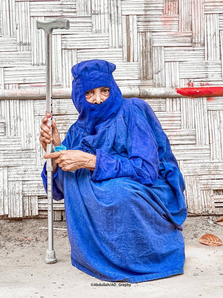 An elderly Rohingya woman with a traditional burkha was found resting in the refugee camp. In Arakan, almost every Rohingya woman used to wear this kind of burkha in ancient times, and it is assumed to be a traditional costume

#traditionalwear #burkha #RohingyaWomen #culture
