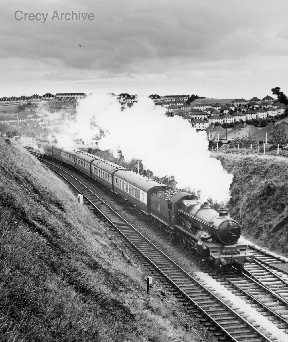 One of the very first batch of GWR Castles, dating from 1923, No 4077 Chepstow Castle, is in charge of a Plymouth to Penzance stopping service seen near St Budeaux on the outskirts of Plymouth, on 31 July 1956