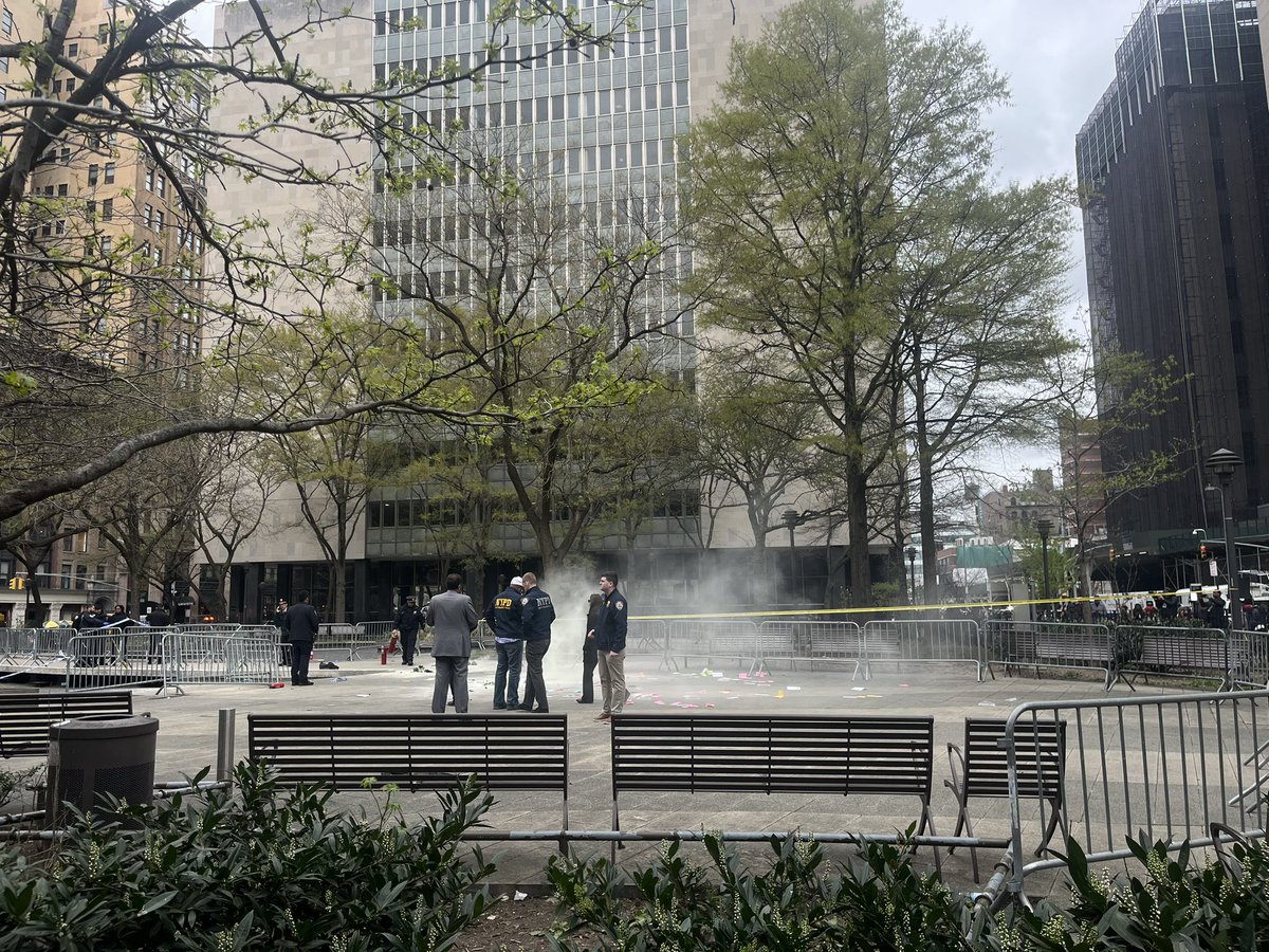 At the scene of the reported self immolation across the street, ash billows towards the criminal courthouse. Police officers are standing around with horrified, frozen expressions. The smell is unlike anything I have ever encountered. This is horrific.