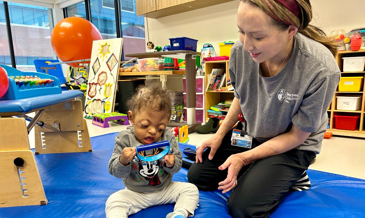 Happy #OccupationalTherapy Month to Lisa! She's with Jeremiah, who was born with Apert Syndrome, when the skull fuses too early, putting pressure on the brain. The bones in his hands and feet also fused together. Lisa helps him re-learn how to balance, crawl, and grab toys!