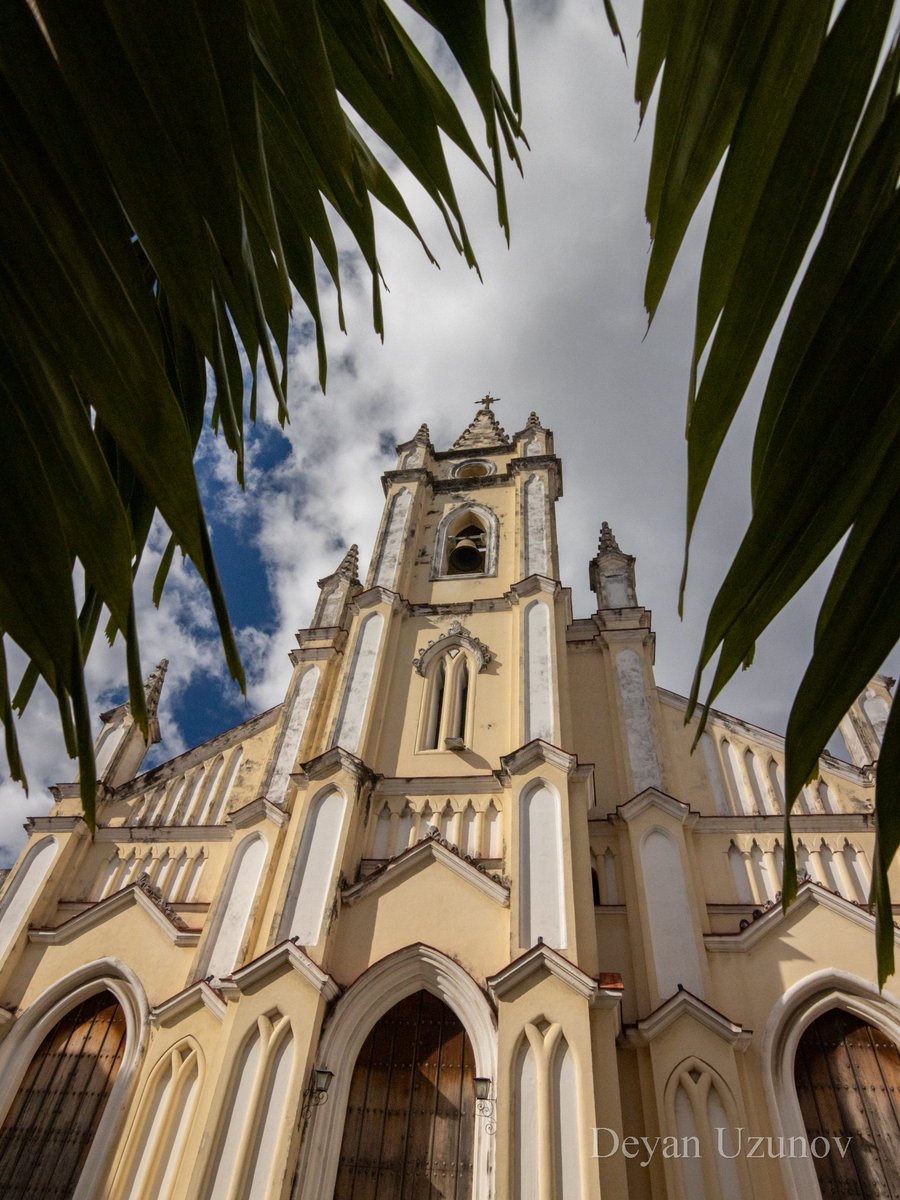 Church of the Holy Guardian Angel, Havana In the heart of Havana, the Church of the Holy Guardian Angel emerges as a timeless symbol of faith and heritage. Framed by vibrant palm leaves and set against a backdrop of soft, billowing clouds, this architectural marvel invites.