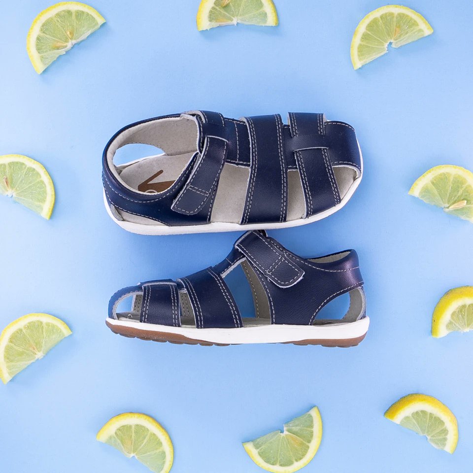 When life gives you lemons... make lemonade in the Jude Navy Leather! 🍋 A classic leather design and protective closed toe combine to create a summer sandal that's ready for anything.⁠ bit.ly/44a4ytw #seekairun #kidsstyle #kidsshoes #kidssneakers #springshoes