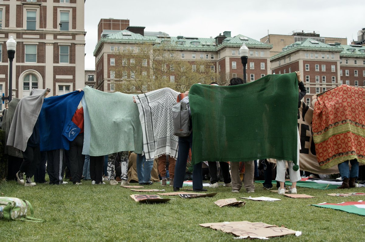 Columbia University students formed a human shield with blankets to provide privacy to others participating in Friday prayer after pro-zionist accounts on social media published a video showing students praying on the lawn. Credit: Katie Smith