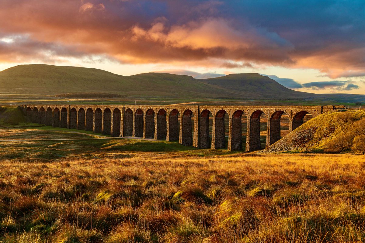 We're kicking off the weekend in the #YorkshireDales with this fantastic image of #Ribblehead Viaduct, taken at sunset a few weeks back by @AkroydNick 🙏

The Viaduct has 24 massive stone arches which tower over the moor at 104 feet (32 metres). 

#BattyMoss #RibbleheadViaduct