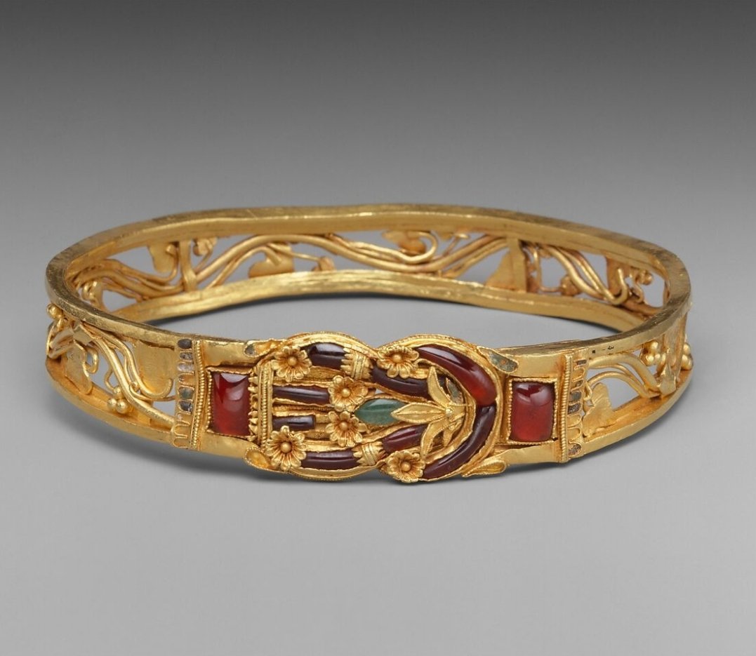 Hellenistic gold armlet with Herakles knot. Inlaid with garnets, emeralds, and enamel. Dated 3rd–2nd century BCE. Metropolitan Museum of Art, New York  (1999.209) metmuseum.org/art/collection…