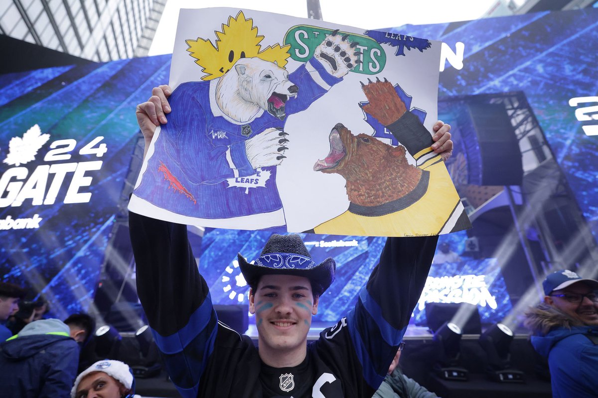 Battle of the Bears! We need Dwight Schrute to analyze which bear is best. Bruin or Carelton the Bear! Gavin Donner shows off his poster at the tailgate party in Maple Leaf Square as fans gather for @MapleLeafs vs @NHLBruins #NHLPlayoffs2024 game 1. #LeafsForever #LeafsNation