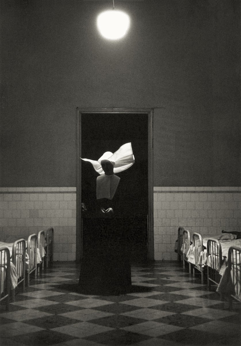 A nun watches orphaned children sleep at Casa de Beneficencia Orphanage in Havana, Cuba. Marvin Koner, 1940s.