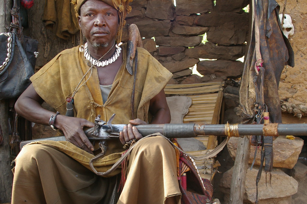 The Dogon people's militia in Mali probably has the most hardcore drip out there. Part post-apocalyptic, part tribal, part unclassifiable. Here are some photos. Thread. 1. Man with a--yes, you guessed it--flintlock rifle. I'm willing to bet it works, too.