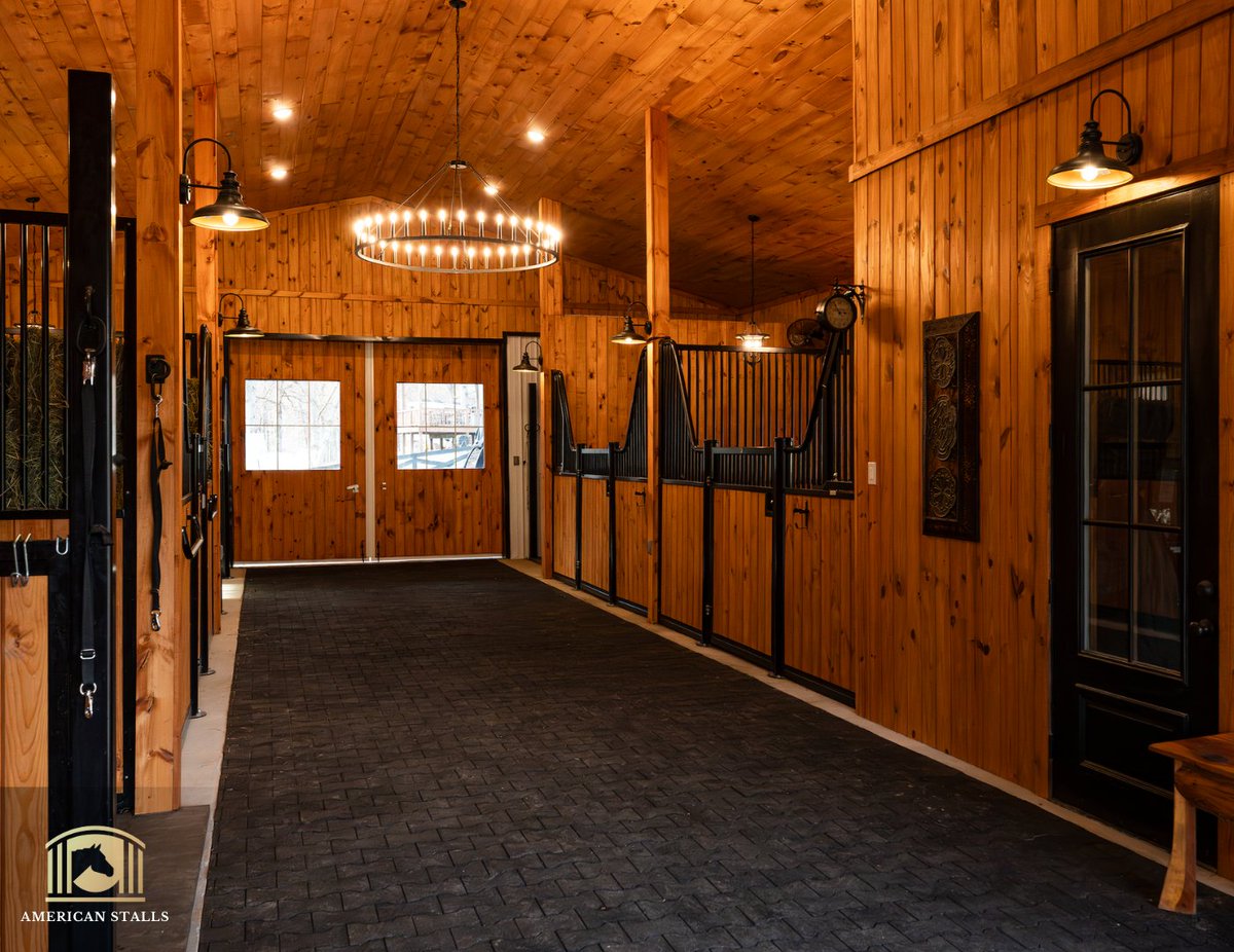 Swooping Stall Fronts. Rubber Pavers that add comfort. Warm lighting. Beautiful Barn doors 🌞 Create an environment that is beautiful inside and out for you and your horses 🐴 

#DreamBarn #Equestrian #StableStyle #HunterJumper #Dressage #Polo #AQHA