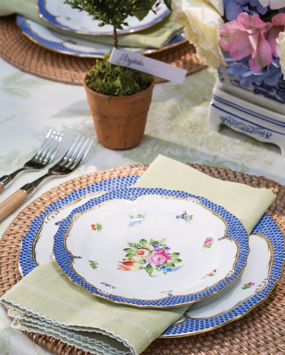 Surrounded by lush environs, a table bedecked in pastel florals and finery beckons guests to relish lunch outdoors and make the most of breezy April weather.

#southernladymag #springtablescapes #springflowers #entertaininginspo #placecards #placesettings #herend