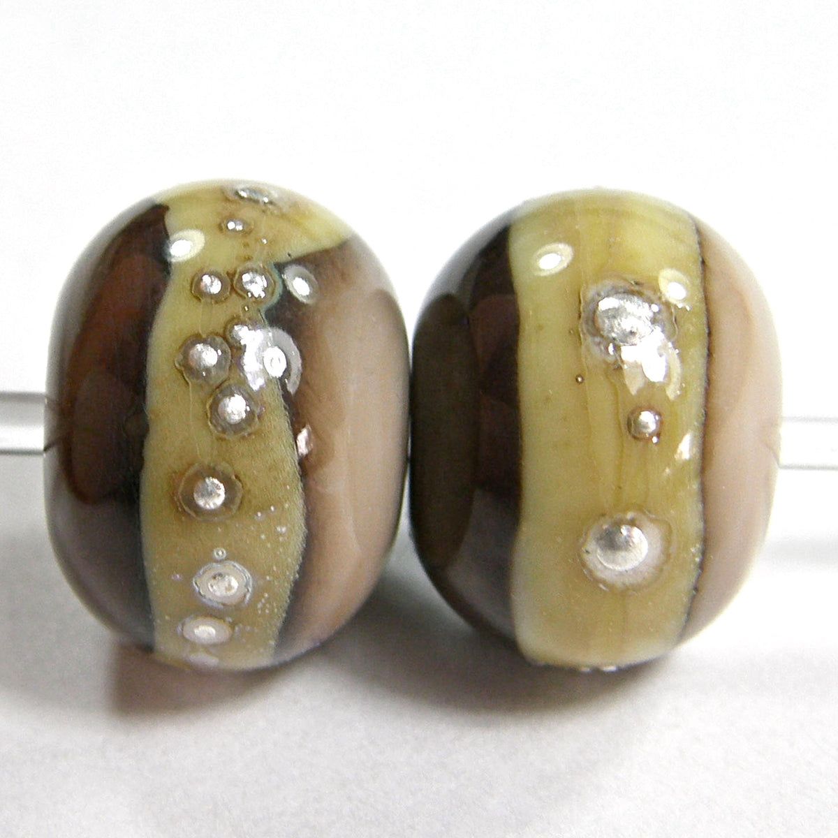Two tone mudslide brown handmade lampwork beads with a silvered ivory band wrapped in fine silver with a shiny glass bead finish bit.ly/TwoToneMudslid… via @Covergirlbeads #ejwtt #LampworkBeads #ShopSmall