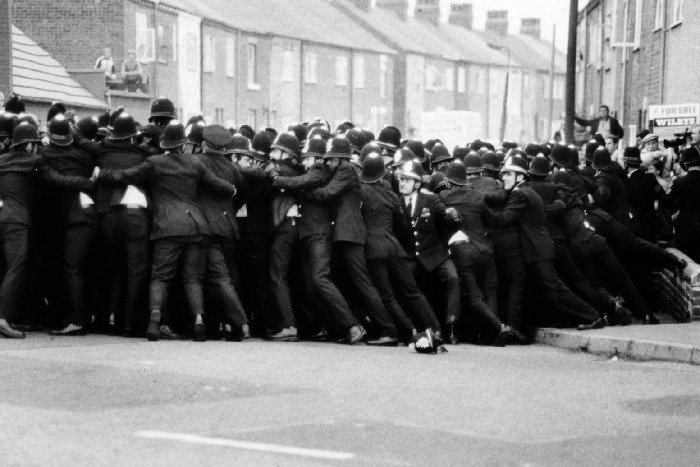 A line of police ‘kettle’ picketing miners in a side street opposite Allerton Bywater Colliery, Yorkshire as three miners went into work #OnThisDay 1984.