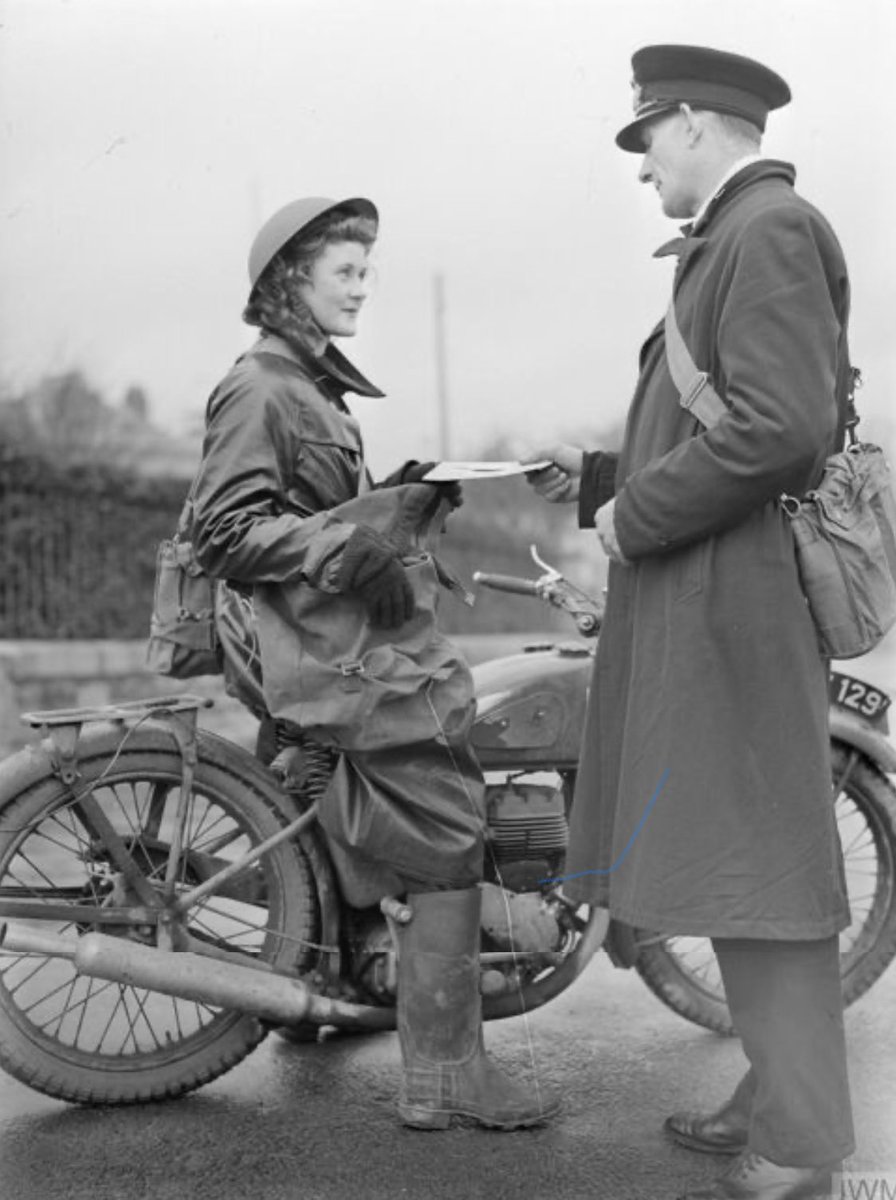 1941. A Wren despatch rider in her wet weather kit receives her orders. Photo taken by Harold WJ Tomlin. IWM pic, ref A2829.