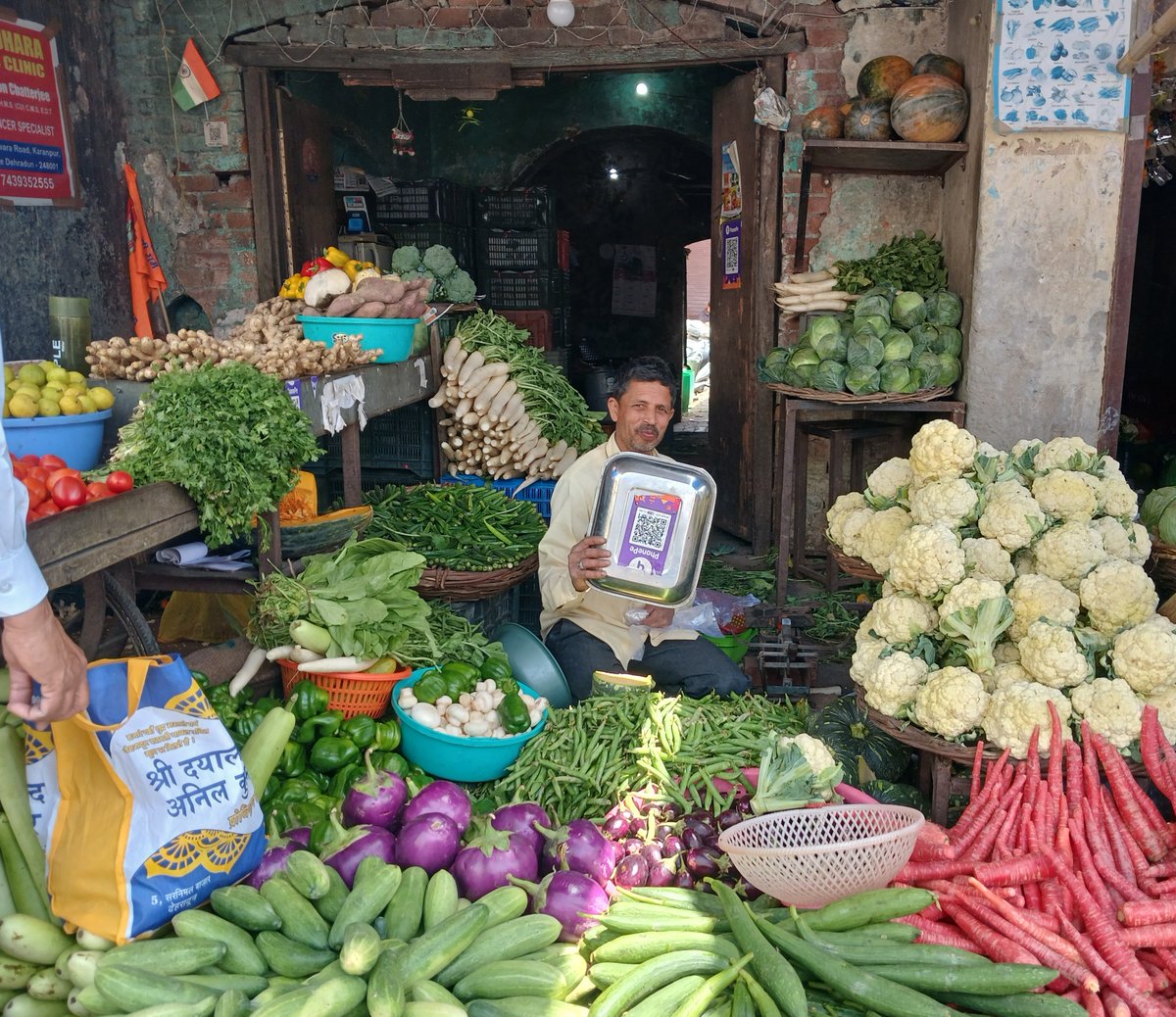 Just as we Indians are super adept in multi-tasking and multi skills, we are equally brilliant at 'multi-utility' of our products and assets. When we asked this local vegetable seller in Sabzi Mandi, Dehradun for the UPI bar code to pay, he promptly turned his weighing pan up…