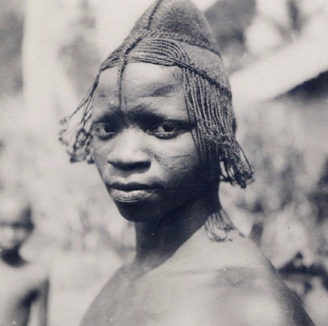 A young Igbo man with plaited hairstyle and uli body and face painting. Photographed by J. Stocker, early 20th century.