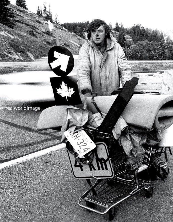 A homeless man pushes his worldly belongings in a shopping cart along the Trans Canada Highway near Canmore, Alberta in the early nineties. Gary Moore photo. Real World Photographs. #photojournalism #Nikon #poverty #Canada #Alberta #realworldphotographs #garymoorephotography