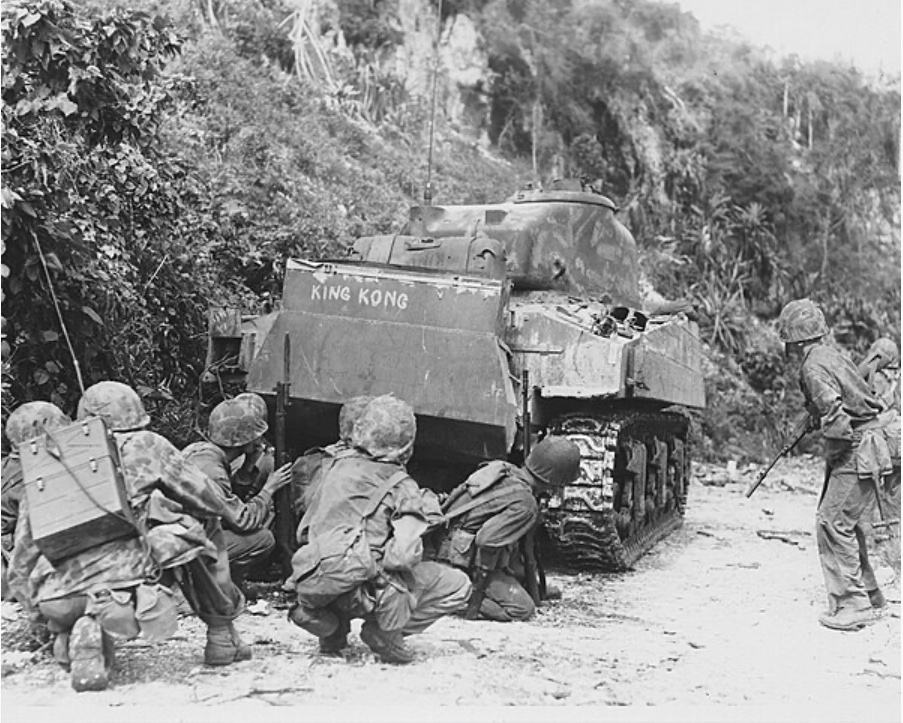 In July of 1944, Marines take cover behind an M4 Sherman tank while clearing Japanese forces in northern Saipan. 🪖