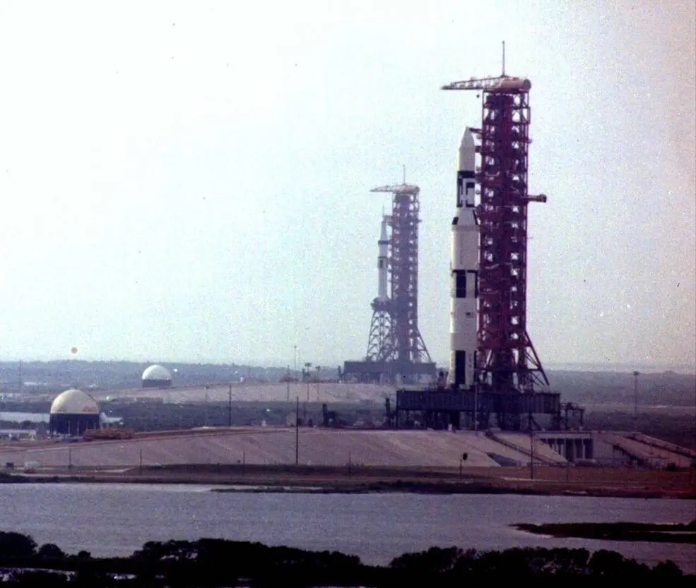 The final Saturn V, carrying Skylab, sits on the pad. At the same time, behind it, the Saturn 1B for Skylab 2 sits on another pad behind it.