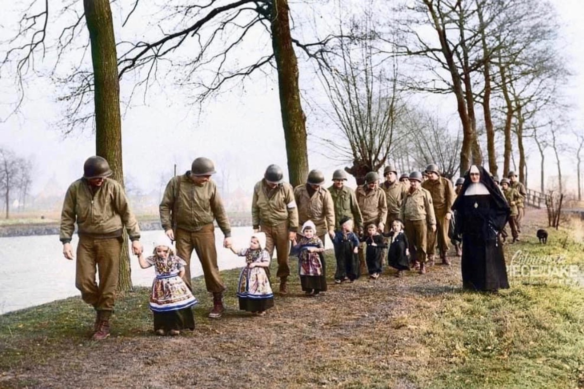 In late 1944, American soldiers accompany young Dutch children on a morning walk through the grounds of Hoensbroek Castle in Limburg, Netherlands. 🪖 @PieceJake on the colorization 🎨