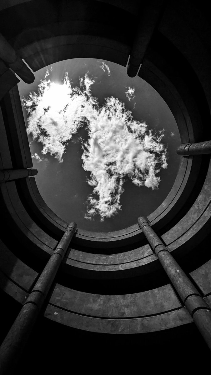 Looking upwards through the parking access ramp of the Tulsa Civic Center #pixel6 #snapseed #architecture #cloud #monochrome