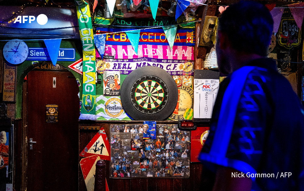 Game on! Dutch darts world hits the Bullseye. The packed stadium shudders as thousands of orange-clad Dutch fans bounce around, chanting the name of their favourite player. But they're not watching Ajax or the Netherlands football team. This is darts u.afp.com/5AFb