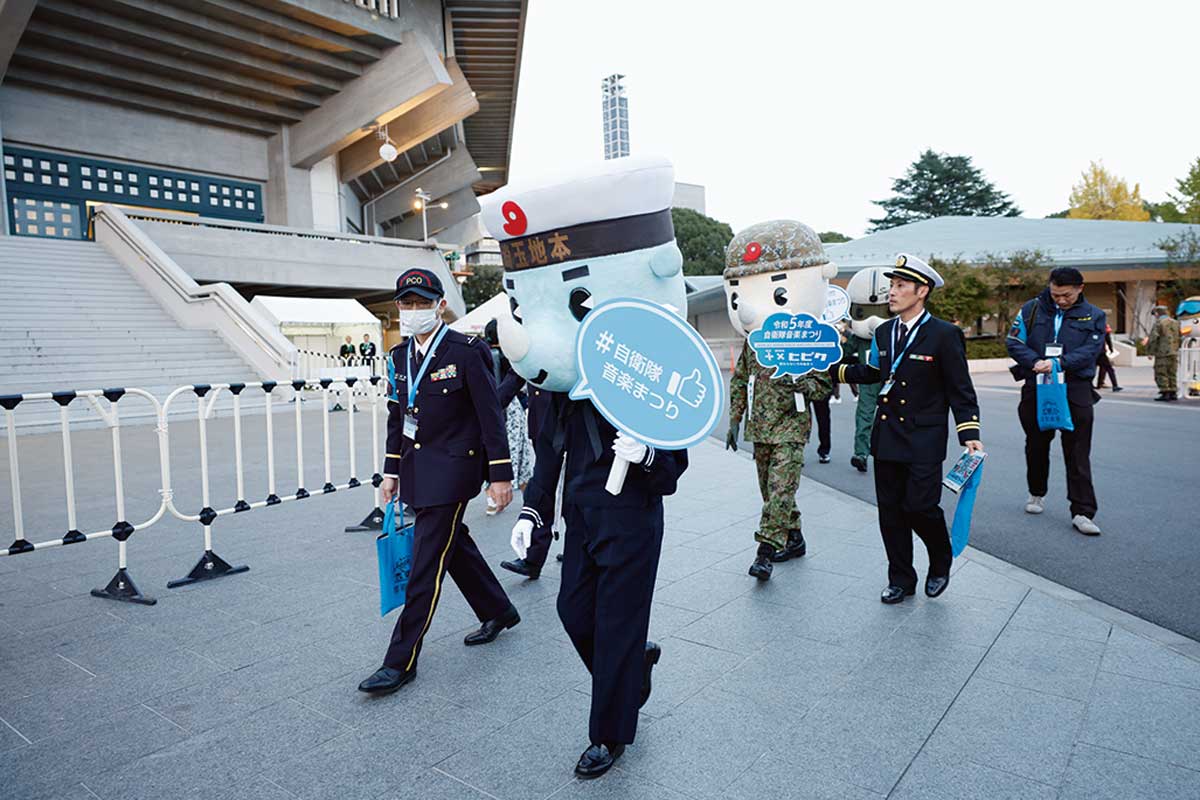 【「自衛隊音楽まつり」開催までの舞台裏】 当日は、会場の外に地方協力本部による広報ブースも設置され、キャラクターによるPRも行われる。進行や調整を行うのも企画部の役割だ mamor-web.jp/_ct/17681803