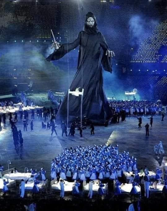 Predictive Programming: The opening ceremony of the 2012 Olympics in London featured a giant figure of death holding a Needle, with doctors and nurses dancing like zombies around children in hospital beds .. 💉