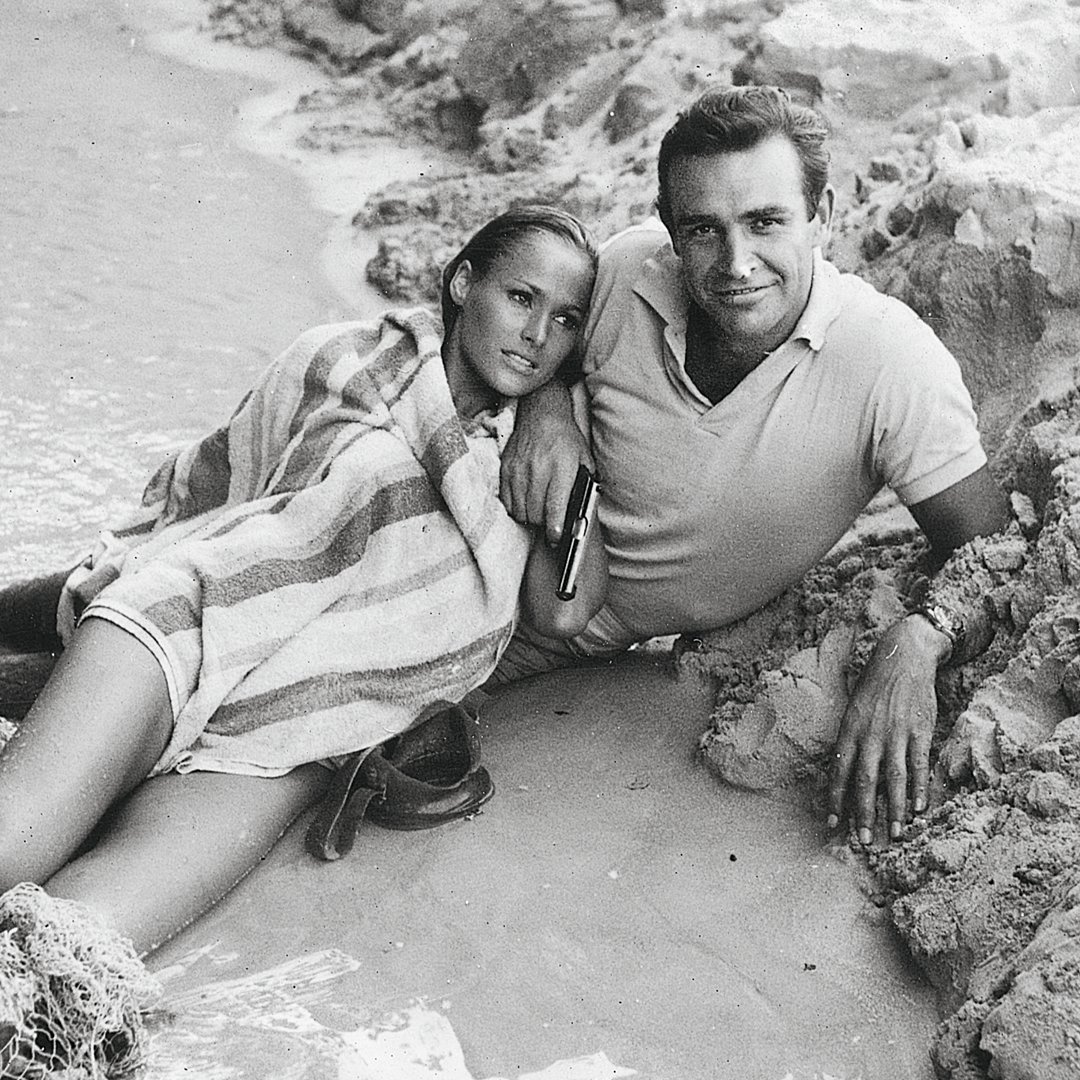 Filming wrapped on DR. NO on this day in 1962. Pictured are Sean Connery, Ursula Andress plus cast and crew filming in Jamaica. Photography by Bert Cann.