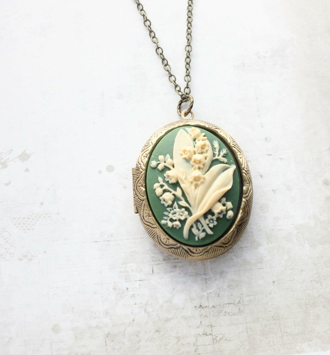 Lily of the Valley Locket

This is a large antiqued gold brass photo locket with a beautiful lily of the valley cameo in green and ivory cream.

The locket measures 1.5'w x 1.75 'h (36mm x 45mm) and has two oval frames inside.
#carrboro #chapelhill #mymusescardshop