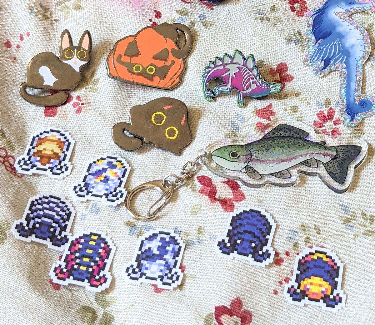 @Slothie_Studios @wormsandbones Cat pins are from @KikiDoodleTweet Isopods pixel stickers from @LCSkeleton Dino pin and fishy charm from @Saberdani Give them a follow, they all capture critters so well!