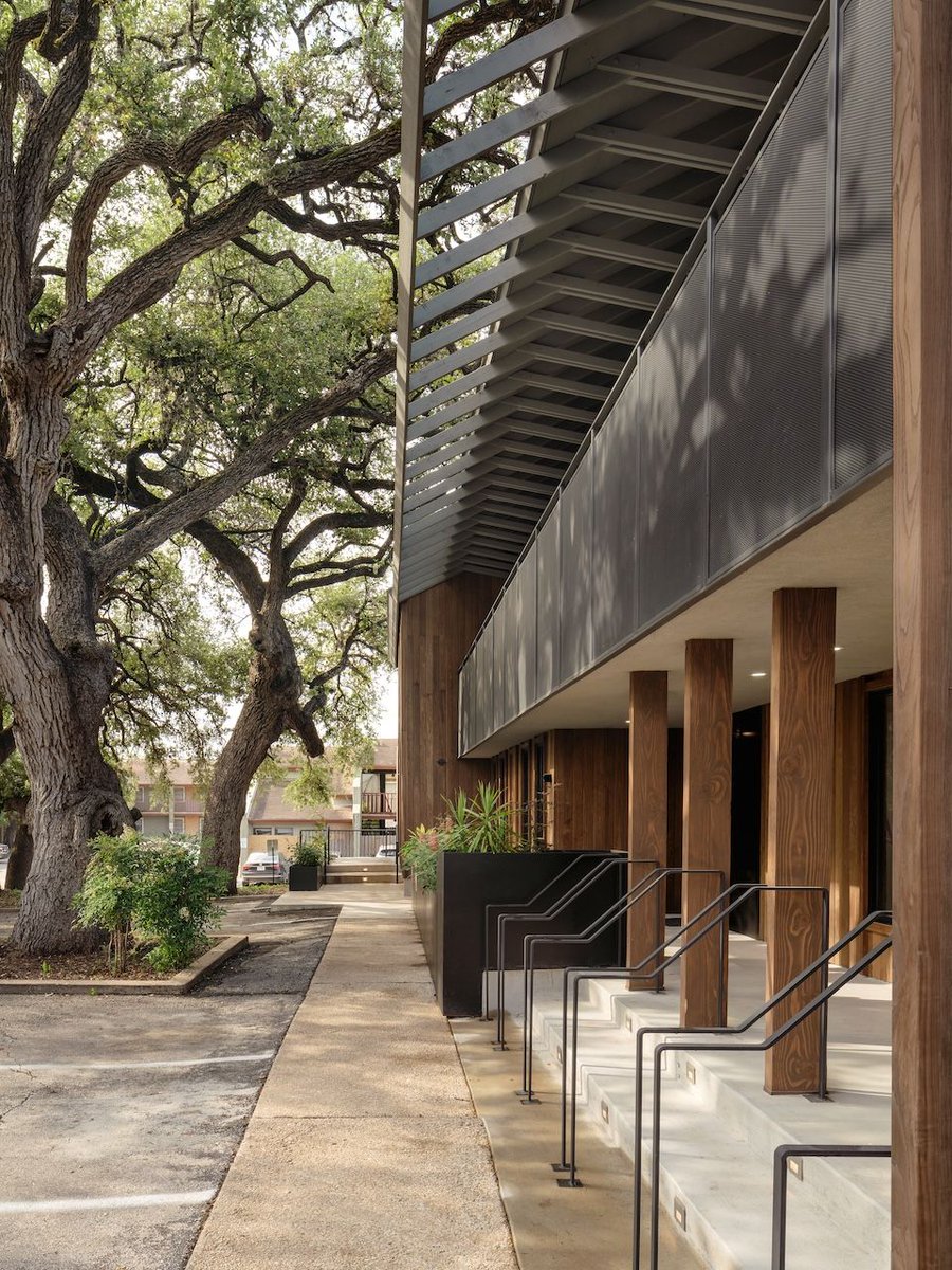 2121 S. Lamar transforms an 80s office building with a raised roof & modern materials. Thermally modified ash wood and blackened steel redefine its exterior, while a new balcony set among oak trees serves as an urban retreat. Details: arc.ht/4aGK8KW | 📍 Austin, TX, US