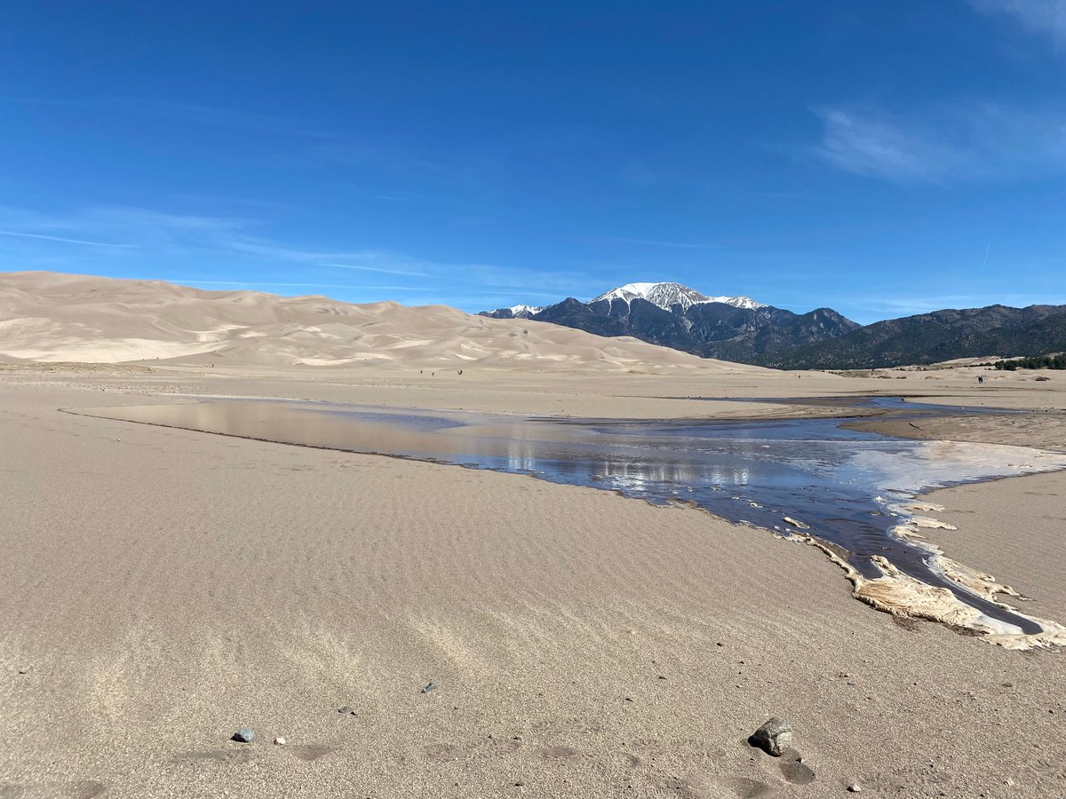 We're so happy to announce that Medano Creek has reached the parking lot at the Great Sand Dunes, right on time for "We 🧡 Our National Park" month! Colorado's best beach appearing is a sure sign that summer is right around the corner😎 #visitalamosa 
📸: Fred Bunch/NPS