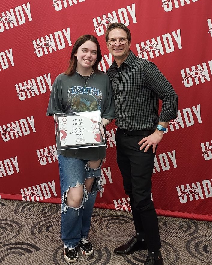 UIndy_English's tweet photo. Many congratulations to Sophomore English Creative Writing Major Piper Parks won the 2024 @UIndy Emerging Leader Award for her work with the Kellogg Writers Series! Pictured here with Professor Barney Haney. Good job, Piper! #GoHounds #uindy #uindyenglish https://t.co/VLyJTih20e