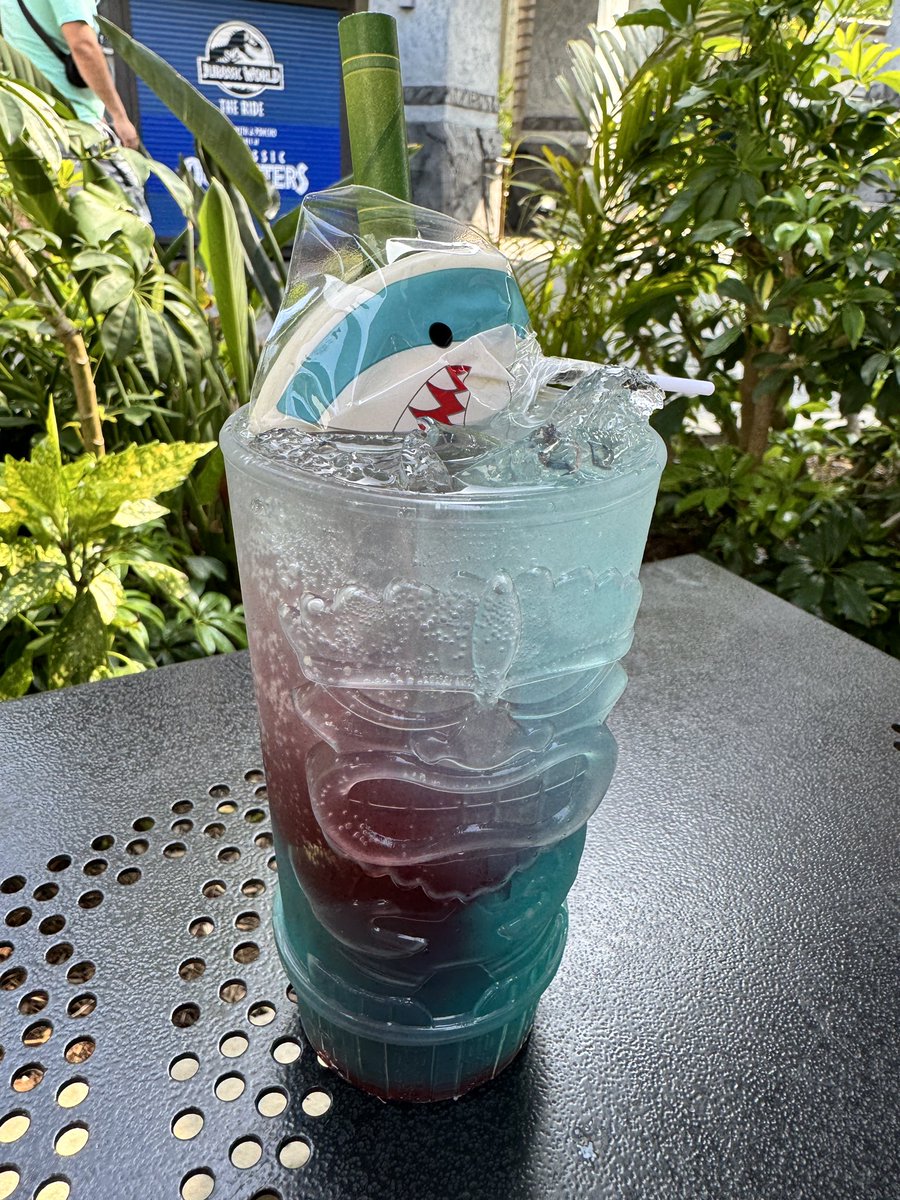 💎🍸Surprise! There are 60th anniversary specialty cocktails sprinkled throughout @UniStudios. This is the Shark Bite from Jurassic Cafe: blue curaçao, tequila, Sprite, grenadine, coconut, lemon and a shark lollipop 🦈