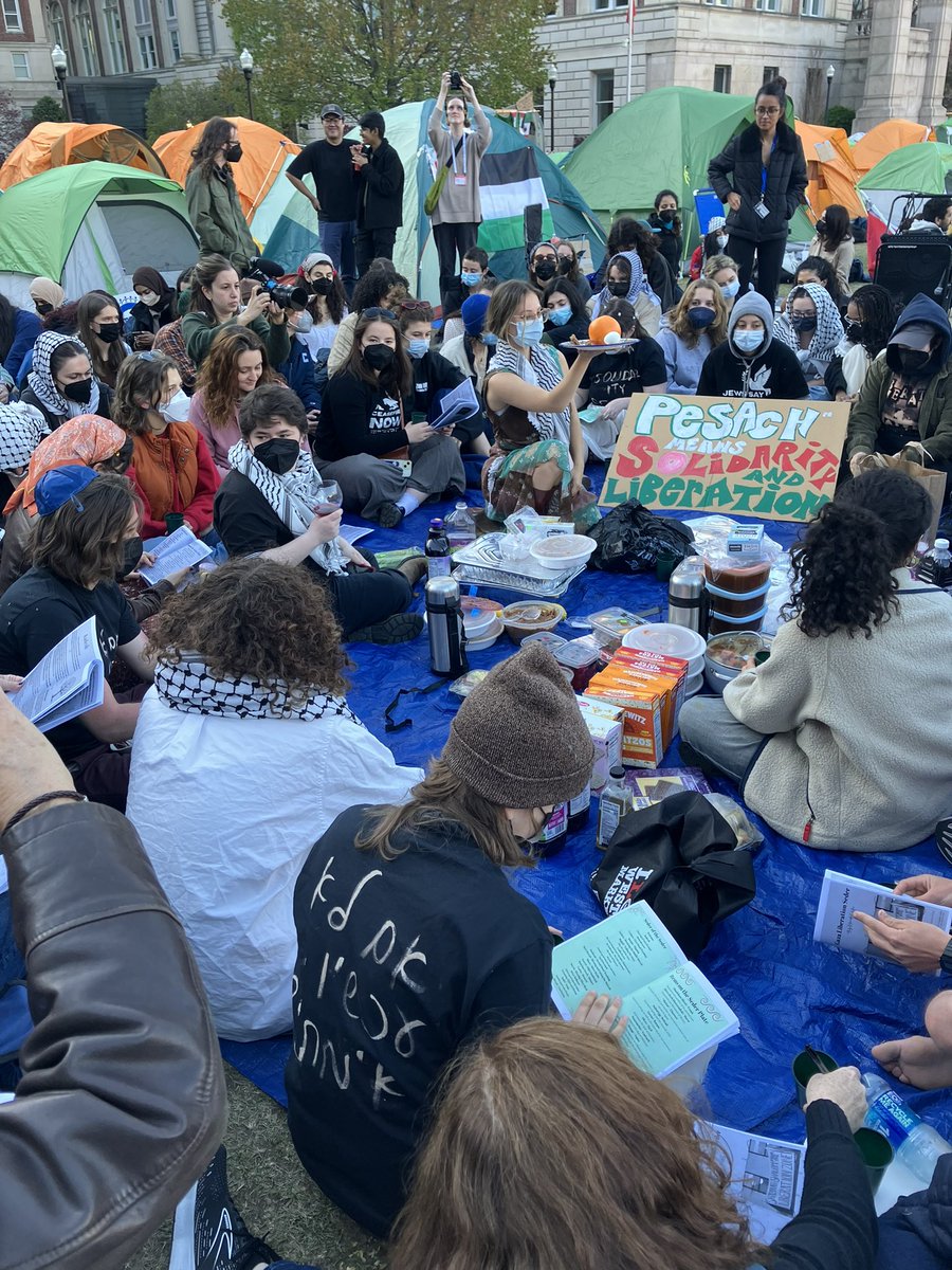 Explaining the seder plate at the Columbia encampment. These students truly embody the meaning of Passover in their provisional seder and their commitment to liberation.