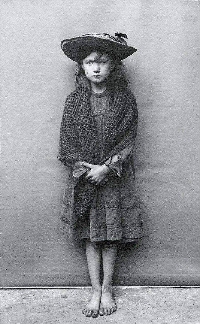 Adelaide Springett, estaba tan avergonzada por el estado de sus botas que se las quitó, representa una fotografía en Londres, 1901. Foto de Horace Warner.