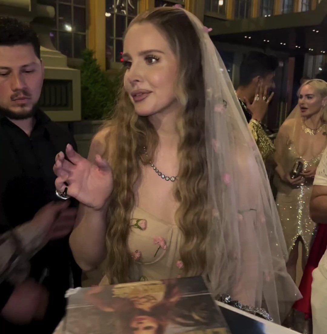 lana del rey signing a 'paradise' vinyl at the met gala’s after party
